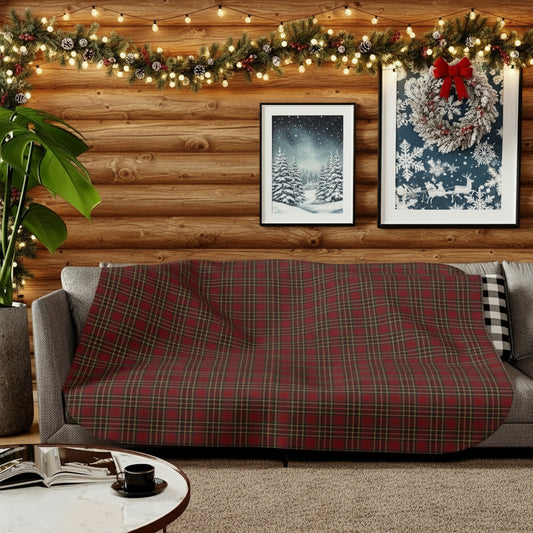 Living room with a plaid blanket on a sofa, wooden walls, and nature-themed wall art.