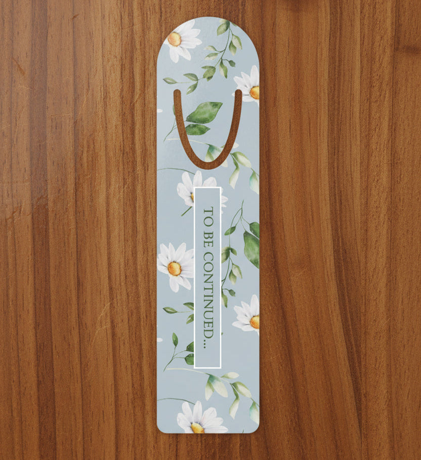 Floral aluminum bookmark with daisies and the phrase To Be Continued