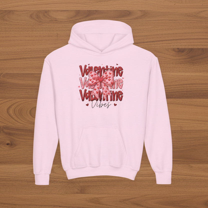 Pink hoodie with Valentine's Day text design on a wood background