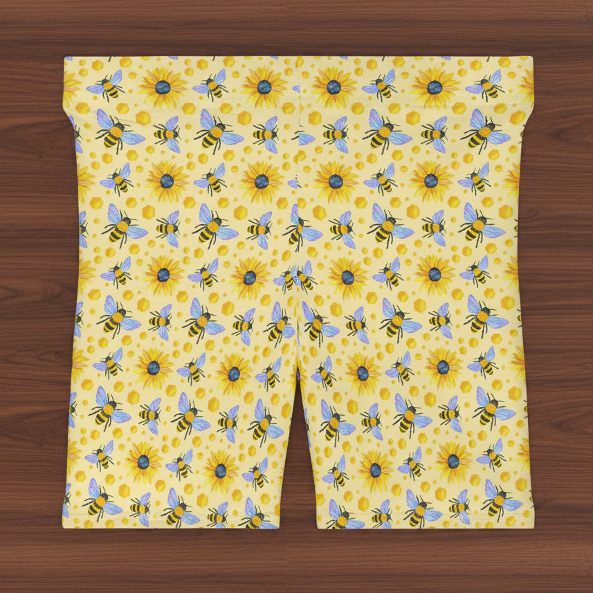 Patterned fabric with bees and sunflowers on a yellow background
